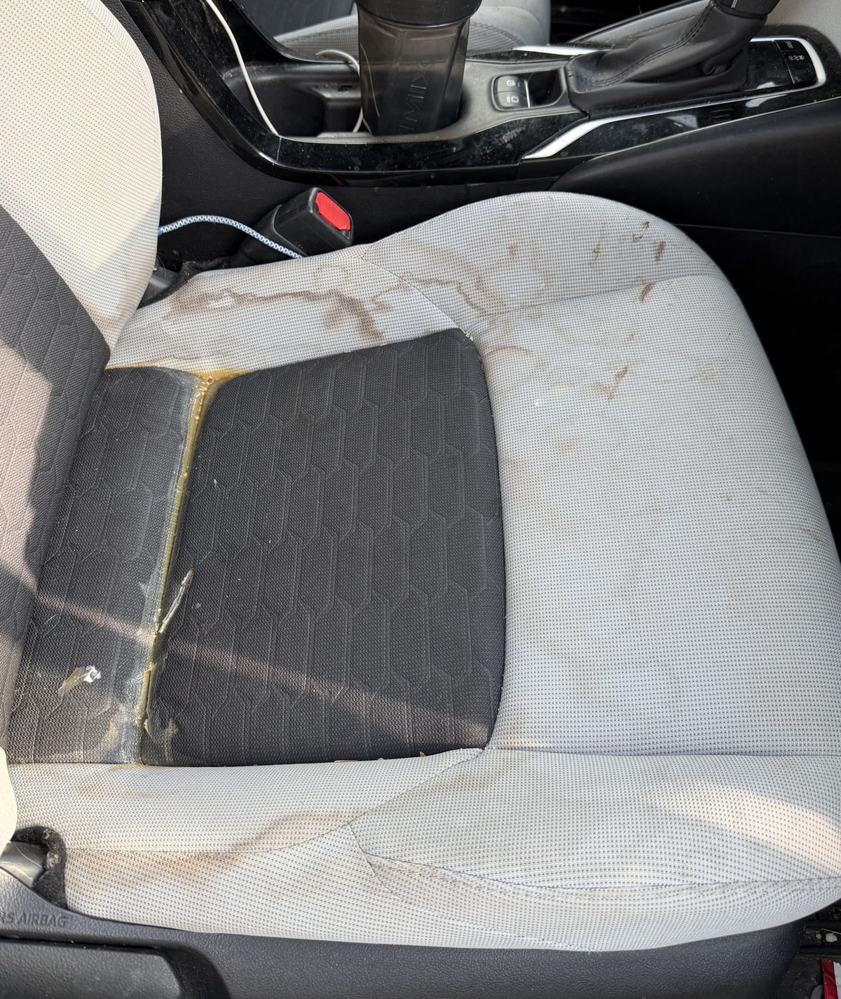 The same cloth seat with heavy brown stains before detailing