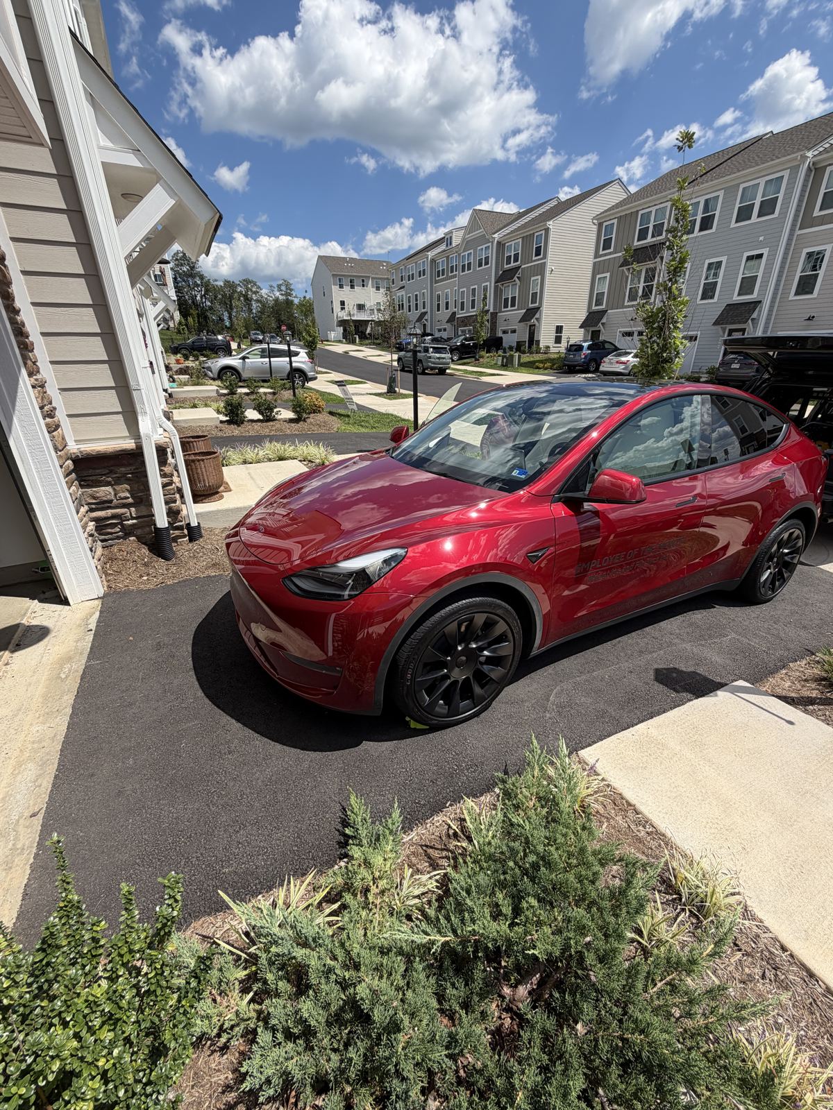 Freshly detailed red Tesla Model Y parked in a Charlottesville-area driveway